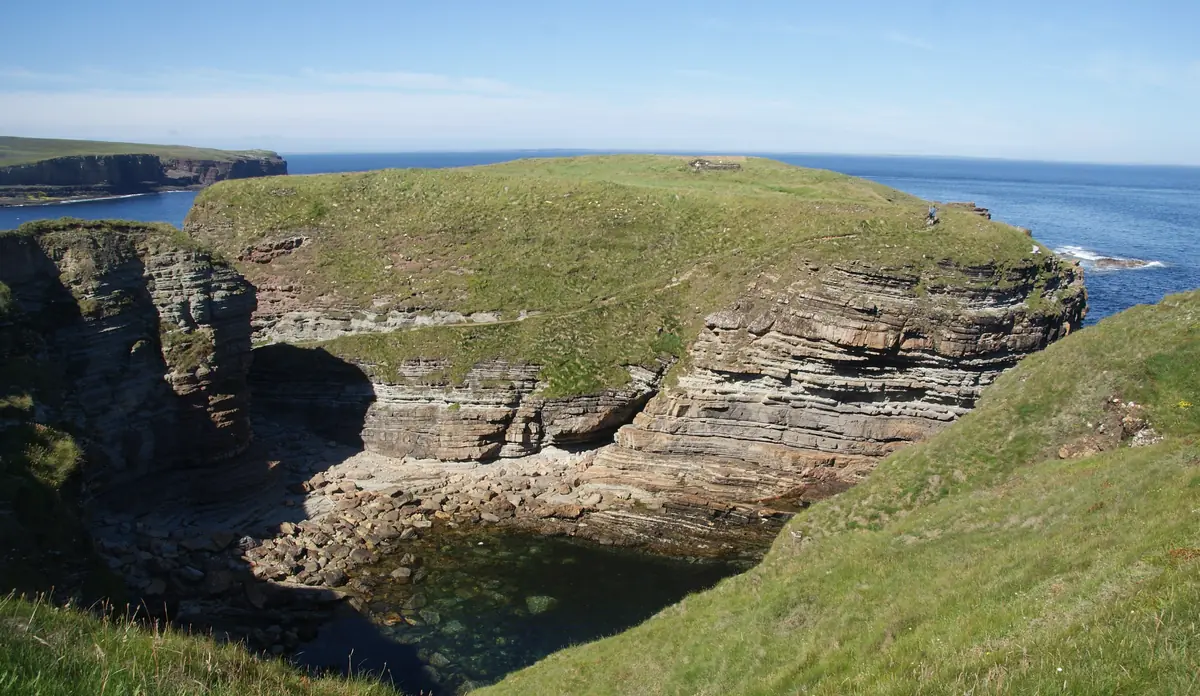 Le scogliere verdi del Brough of Deerness sul mare blu